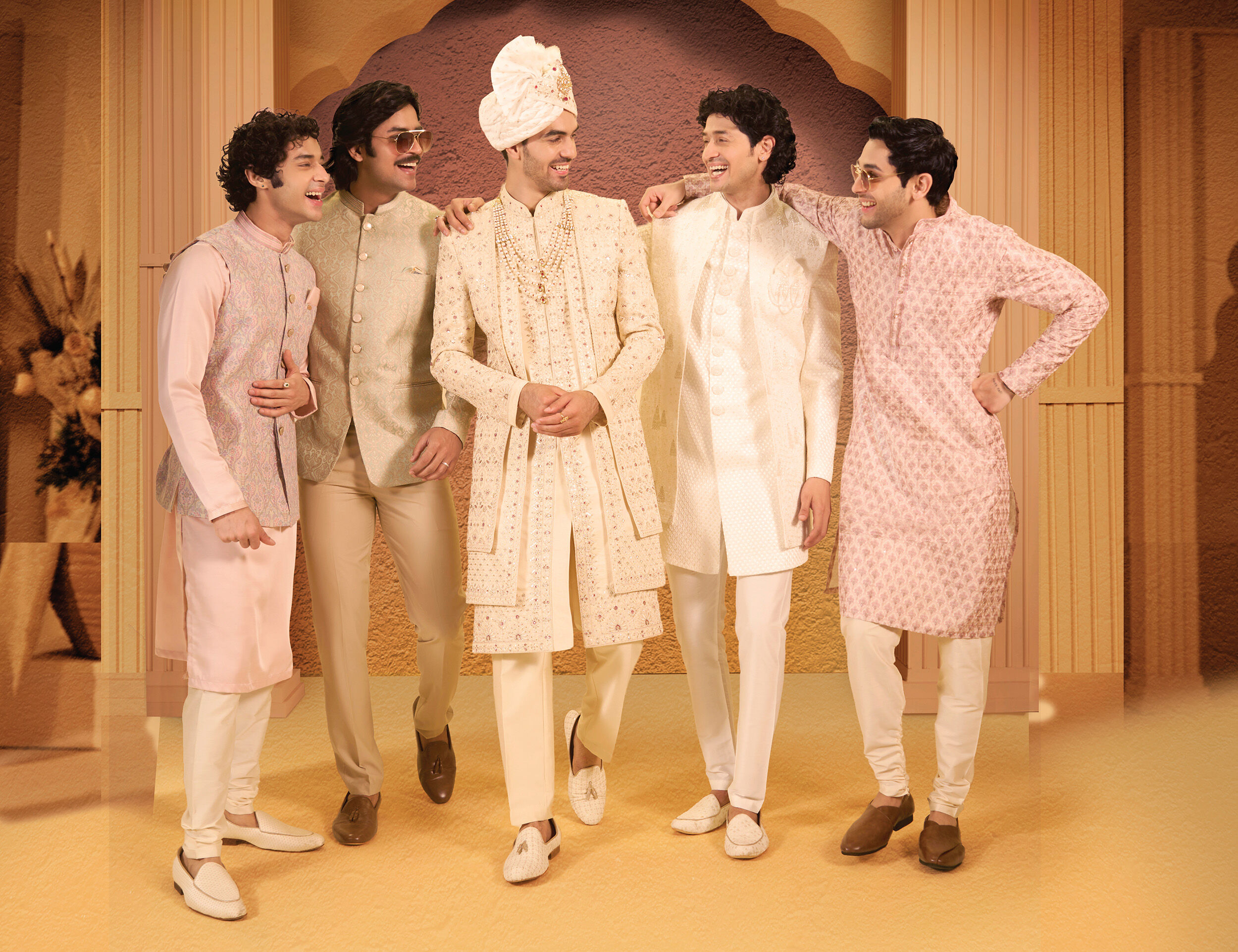 Group of groomsmen and groom in stylish Indian wedding outfits with vibrant color combinations like pastel pink, ivory, and green